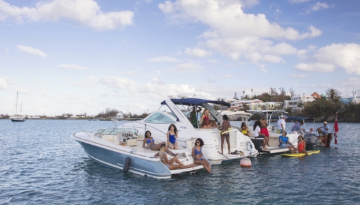 People sitting on the back of boats rafted up together