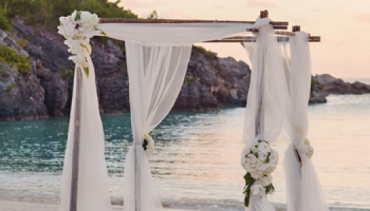 A wedding arch on a beach at sunset