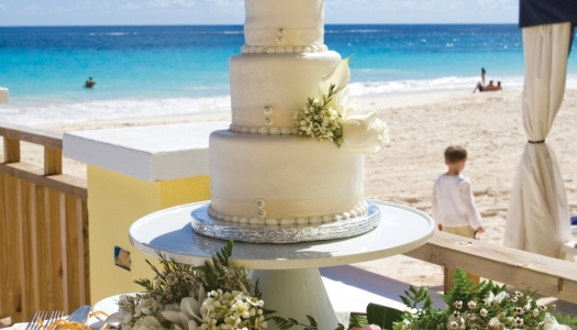 A wedding cake with a beach in the background
