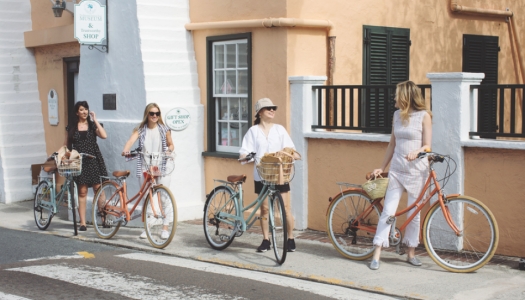 Four women walking their bikes