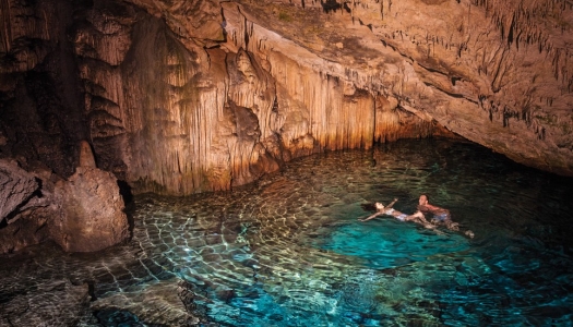 couple swimming in underwater cave