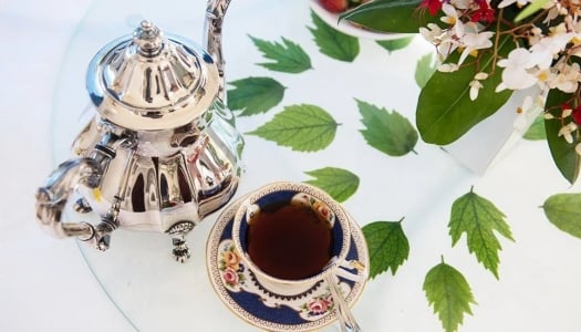 cup of tea with teapot on table