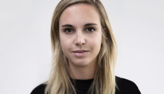 Headshot of a woman with blonde hair and black shirt slightly smiles at the camera