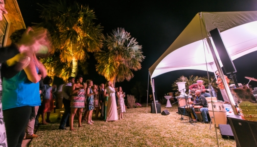 A party at night with a live band performing under a tent