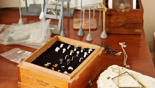 Wooden table of jewelry boxes and holders including rings, earings and neckalces.