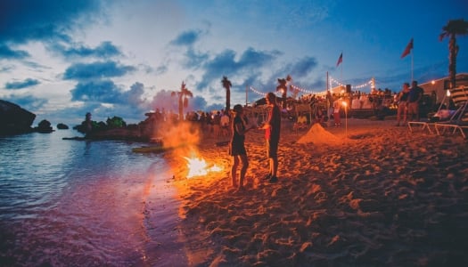 People standing on the beach next to a bonfire at Tobacco Bay