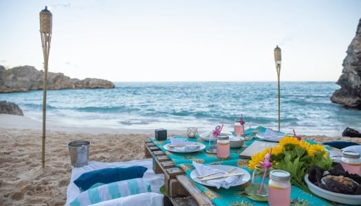picnic table set for dinner on the beach