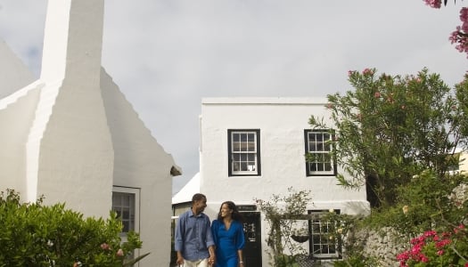 A couple leaves a store with shopping bags in hand in St. George’s, Bermuda.