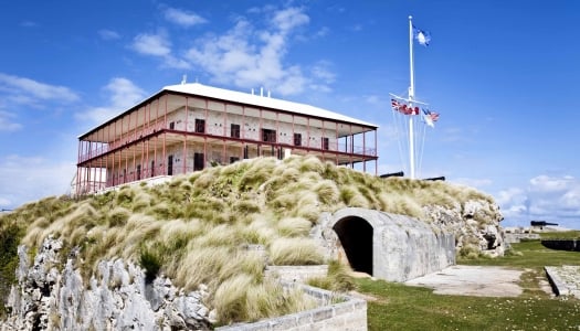 The Commissioner's House sits on a rocky bluff with blue skies in the background