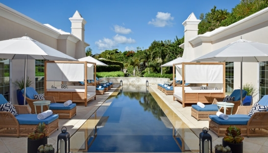 A head on view of a reflection pool and cabanas lined on either side.