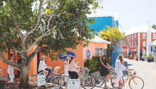 A group of women are riding bicycles in a colourful alley.