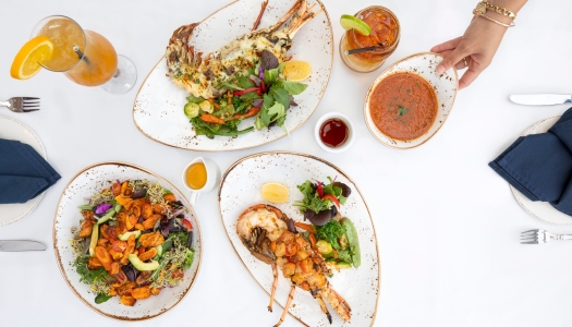 A spread of lobster on a white table with cocktails.