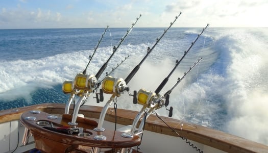 A fishing boat with rods are in the water.