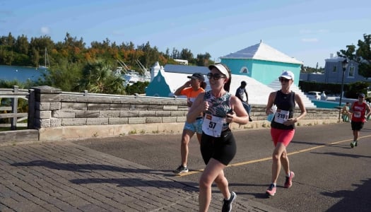 A group of people are running across Somerset bridge. 