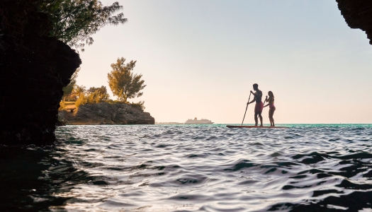 A couple is paddle boarding at Admiralty House