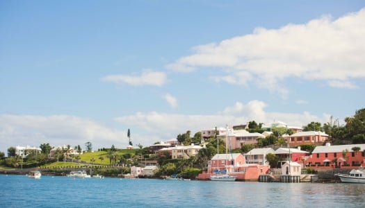 A wide shot of colourful houses from a boat. 