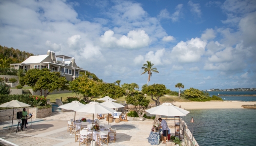 A private island with a house and beach with people on the patio.