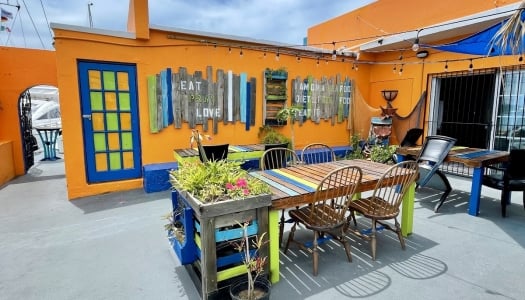 A bright orange building with an outdoor seating area.