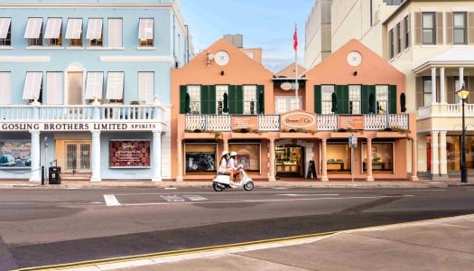 A couple is riding a scooter on colourful Front Street.