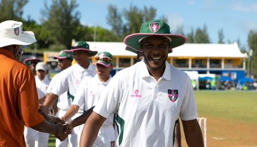 A cricket player is smiling at the camera.