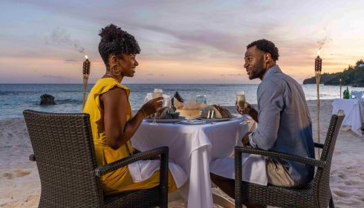 A couple is sitting on the beach.