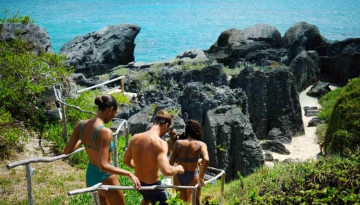 A group of friends are walking down to a secluded beach.