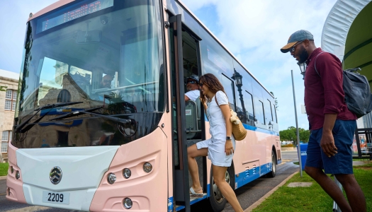 A man and a woman are hoping on an electric bus.