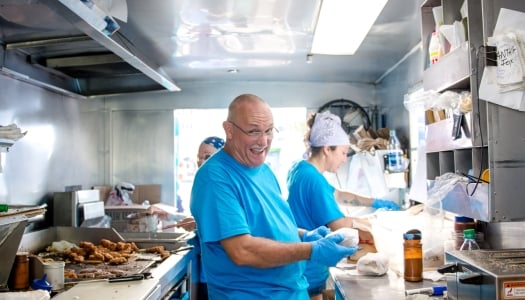 A group of people are cooking in a food truck.