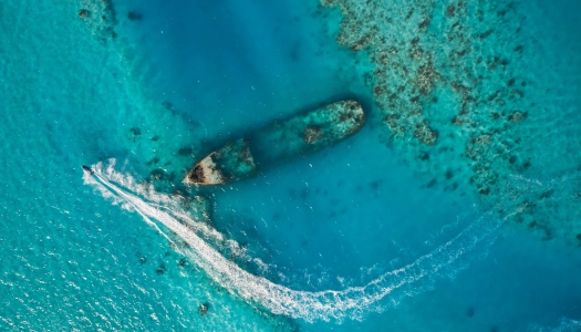 An aerial view of HM vixen with a jet ski driving by.