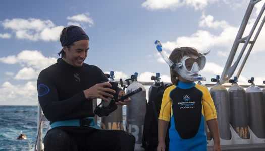 A dad and a son are getting ready to go snorkeling in Bermuda waters.