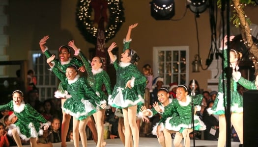 A group of little girls are performing in Elf outfits.