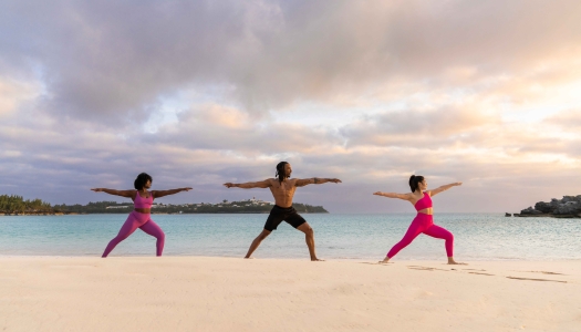 A group of friends are doing yoga on the beach.