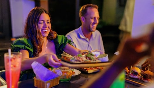 A woman is passing a plate of food around.