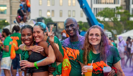 A group of friends are covered with paint at jouvert. 