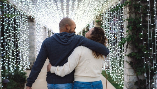 A couple is walking down a lighted alley.