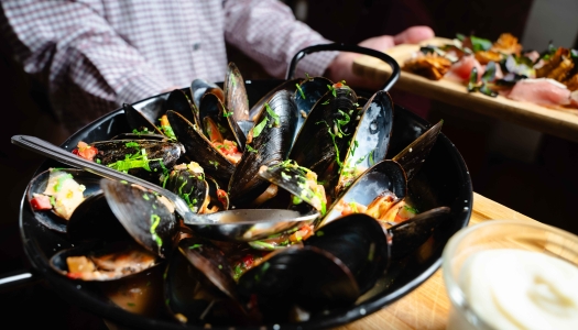 A close up of a bowl of mussels.
