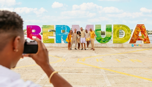People posing by the Bermuda sign.