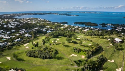 Aerial view of Turtle Hill Golf Course with blue skies and green fairways.