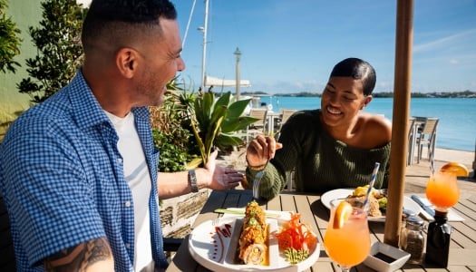 A couple are enjoying lunch at The Wharf by the water.