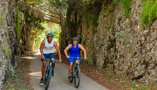 Two guys are riding bikes on the railway trail.