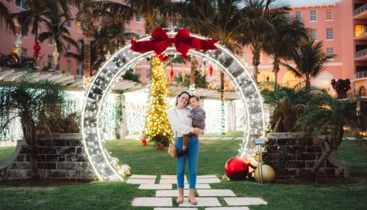 A mother and son are posing under a moongate.