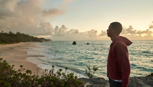 A man is posing by the beach
