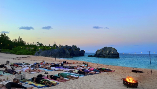 A group of people are doing yoga on the beach