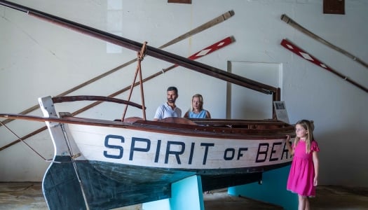 A family are standing by a n old historic boat
