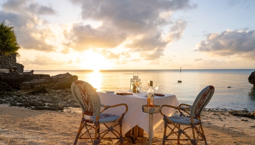 An empty table set up with the sunset setting in the background.