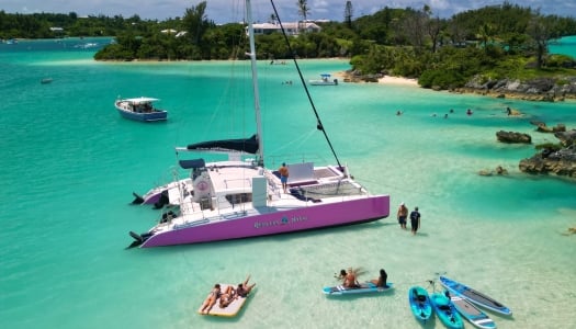A group of people are relaxing by a catamaran