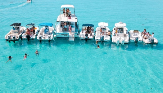 A group of boats and swimmers all together on the turquoise blue waters of Bermuda