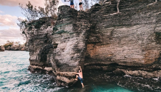 A group of people on a cliff above water