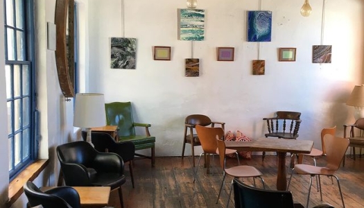 A room with tables and chairs and art on the wall