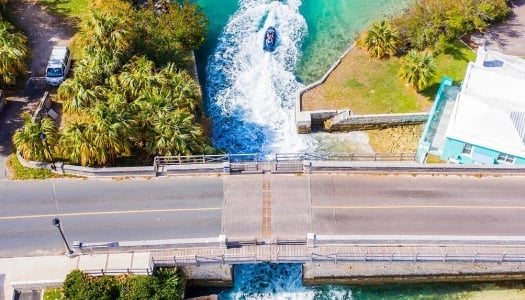 An aerial view of jet skis going under the world's smallest draw bridge.